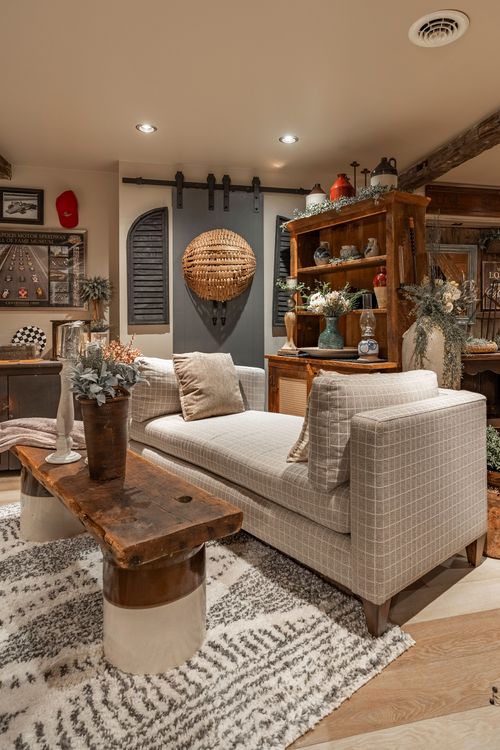 Living room nook with plaid sofa, live-edge coffee table, woven pendant and rustic wood shelving
