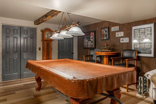 Basement game room with a pool table, grandfather clock and gray paneled doors