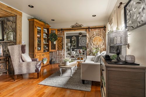 Living room with a wood hutch, sliding barn doors, gray sofa, and hardwood floors