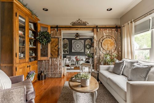 Living room with a wood hutch and sliding barn doors opening to a dining area beyond