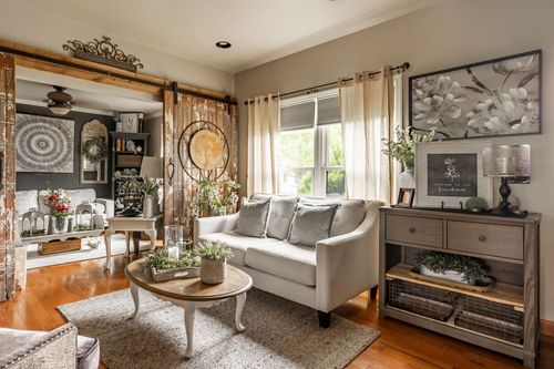 Living room with a farmhouse hutch, sliding barn doors, and a gray sofa seating group