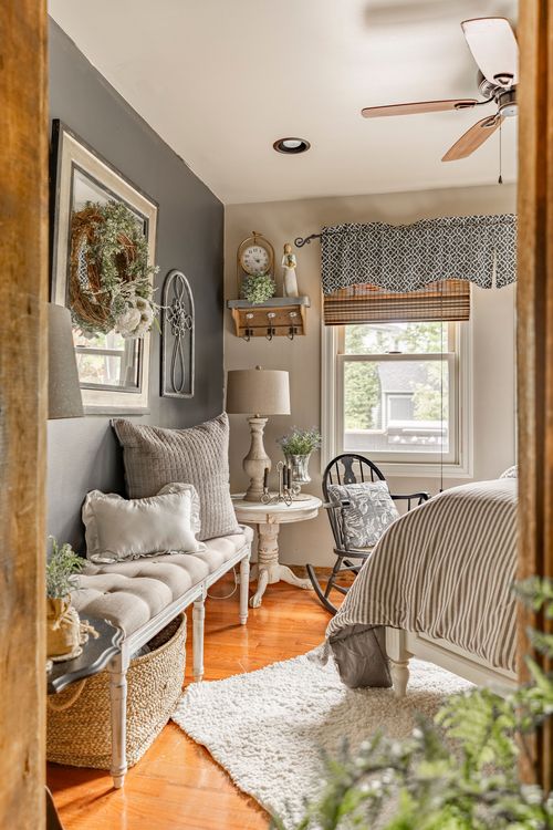 Guest room bench seating with farmhouse decor, valance curtains, and a glimpse of the bed beyond