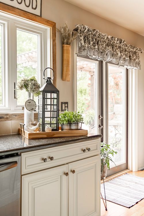 Kitchen counter corner with wood-framed windows, a lantern, and a sliding glass door to the deck