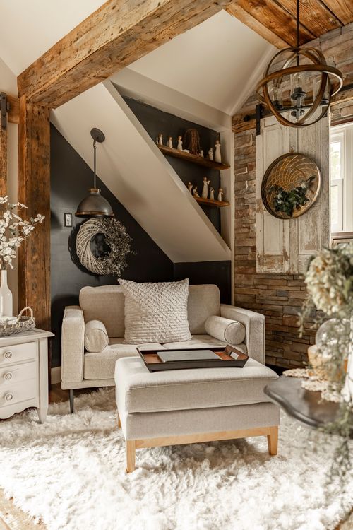 Reading nook under sloped eaves with built-in shelving, a wreathed pendant light, and an upholstered chair