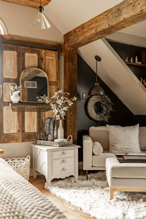 Sitting area with a reclaimed wood barn door mirror, dark accent wall, and upholstered armchair