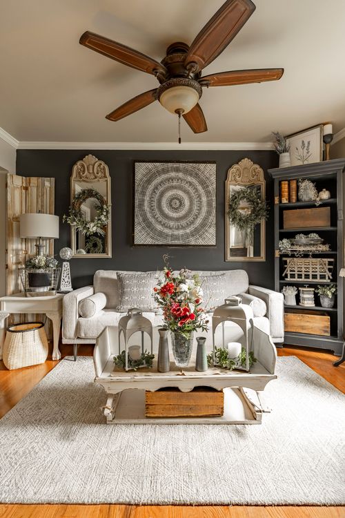 Living room with a dark accent wall, round tapestry art, wreathed mirrors, and a gray sofa