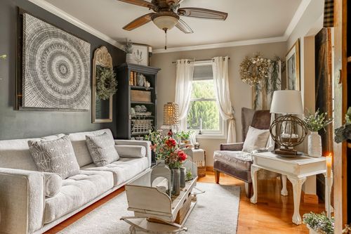 Living room seating area with a gray sofa, farmhouse bookcase, and side table lamp