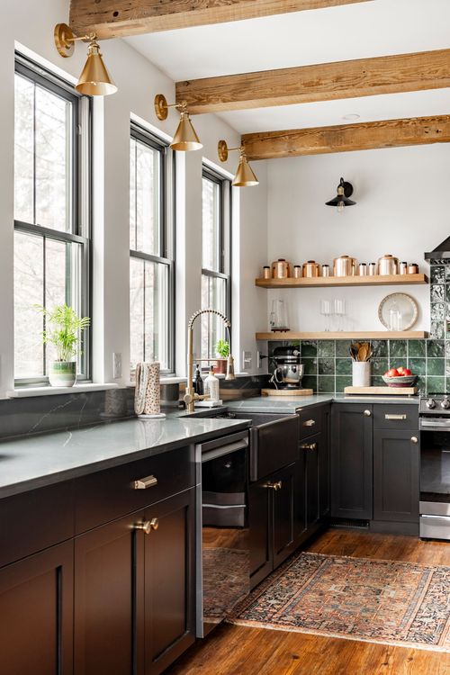 Kitchen with black farmhouse sink, brass fixtures, wood beams and a vintage runner rug