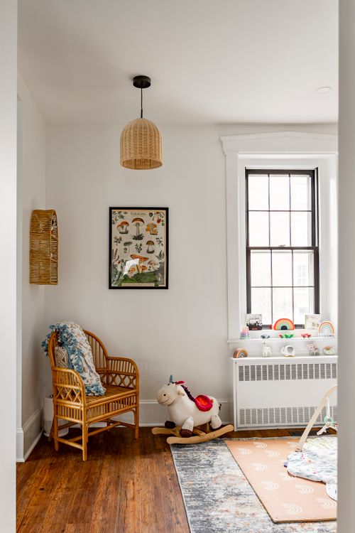 Nursery corner with a rattan chair, mushroom print, rocking horse and dormer window