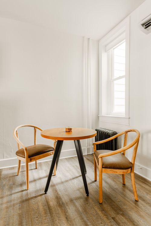 Small dining nook with a round wood table and bentwood chairs beside a window