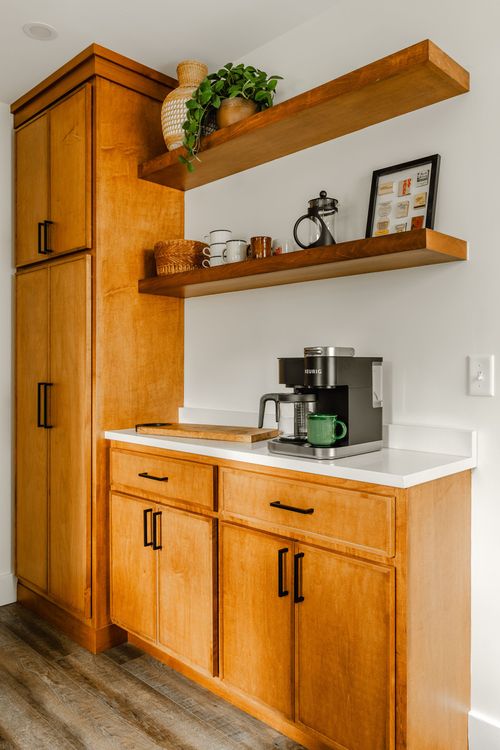 Coffee station with floating wood shelves, a Keurig and warm wood cabinetry