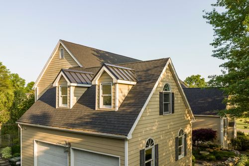 Roofline with twin dormers and an arched window above a two-car garage