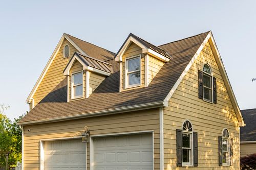 Close-up of twin gable dormers above a two-car garage with an arched window
