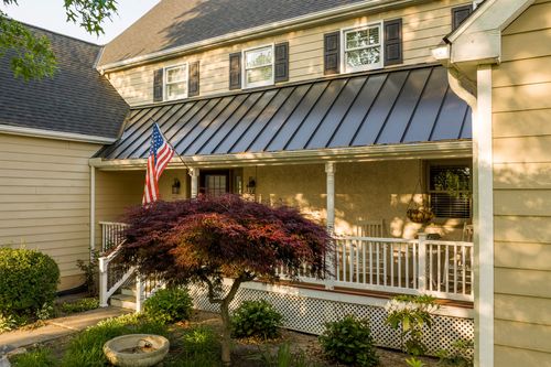 Front garden with a stone birdbath, Japanese maple and wraparound porch